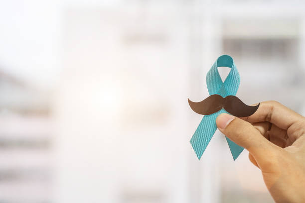 mois de sensibilisation au cancer de la prostate de novembre, homme retenant le ruban bleu avec la moustache pour soutenir des personnes vivant et maladie. soins de santé, hommes internationaux, père et concept de la journée mondiale du cancer - social awareness symbol photos photos et images de collection