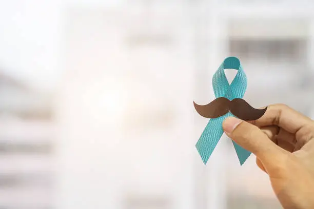 November Prostate Cancer Awareness month, Man holding Blue Ribbon with mustache  for supporting people living and illness. Healthcare, International men, Father and World cancer day concept