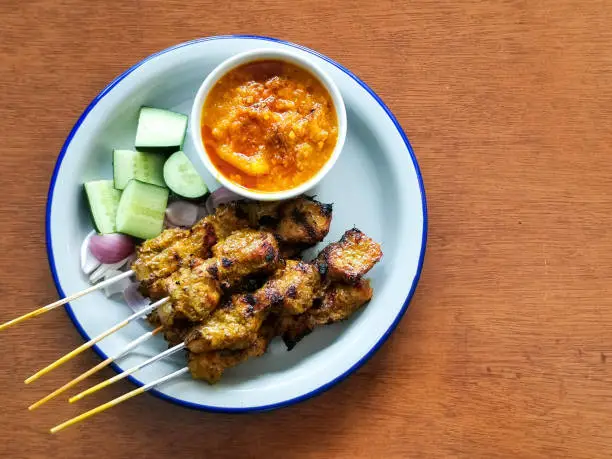 Traditional barbecue skewer with peanut sauce and cucumber
