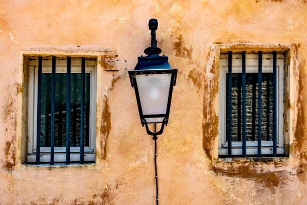 Narrow street, stone houses in a row. Multi colored street light. Old town Pals, Girona province, Catalonia, Spain.