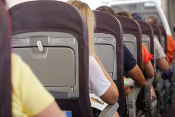 Passengers Inside the plane. Passengers sitting during the flight in economy class Passengers Inside the plane. Passengers sitting during the flight in economy class economy class stock pictures, royalty-free photos & images