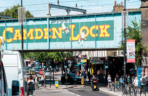 August 18, 2019 – Camden Lock, London, United Kingdom. The famous railway bridge which is overhead the centre of Camden Lock. Tourists flock to Camden Lock for it's shops and stalls that surround the area. Unique items sold everywhere.