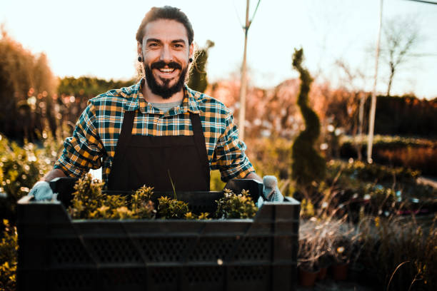istock Guy carrying plants in a garden 1172218126