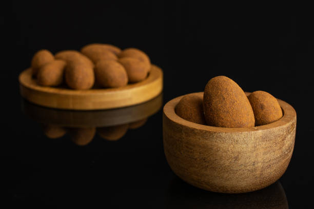 schokolade zimt mandel isoliert auf schwarzem glas - almond variation bamboo bowl stock-fotos und bilder