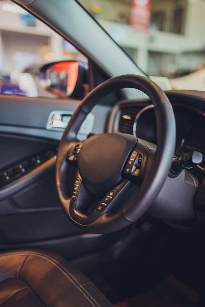 istock Dark luxury car Interior - steering wheel, shift lever and dashboard. Car interior luxury. Beige comfortable seats, steering wheel, dashboard, climate control, speedometer, display, light wood panels. 1172218931