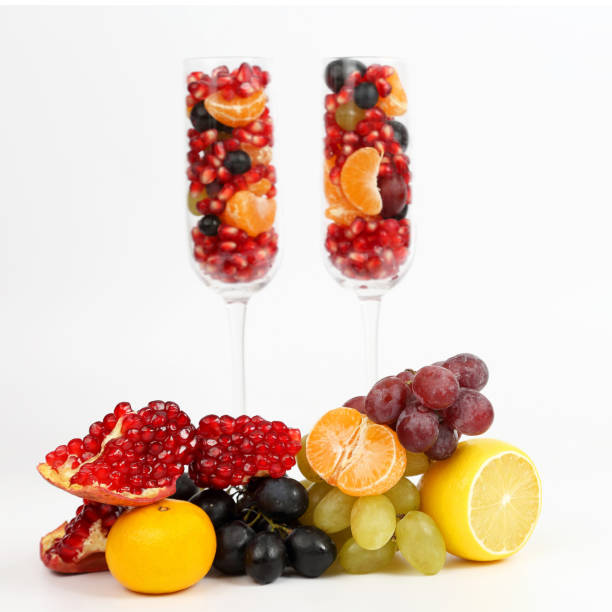 two glasses filled with fruit on a light background
