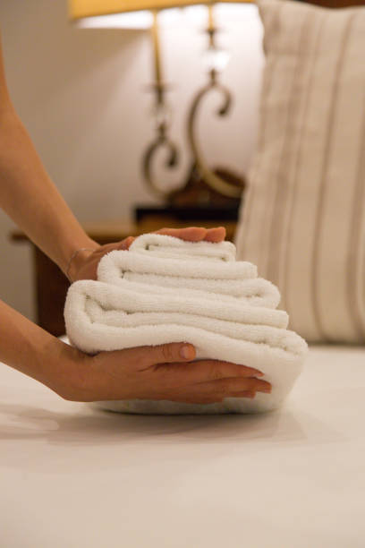 obsługa pokoju. kobieta zmienia ręczniki w pokoju hotelowym. housecleaner kładąc ręczniki na łóżku, przygotowując wszystko, aby klienci - sheet human hand bed women zdjęcia i obrazy z banku zdjęć