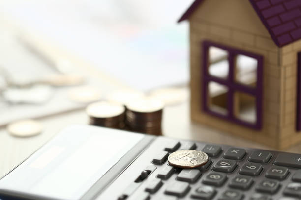 istock Coin Lay on Calculator, House Model on Office Desk 1172224557