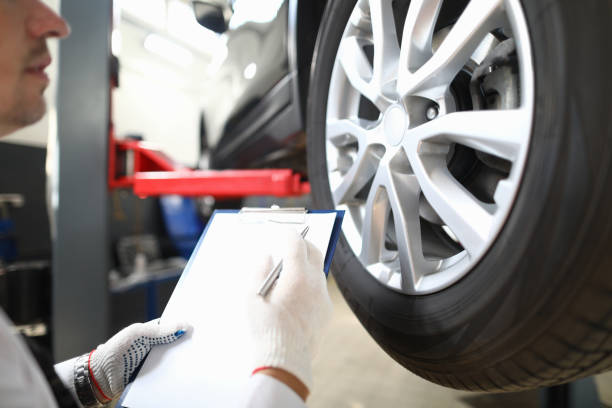 Serviceman inspects a pre-sale vehicle against