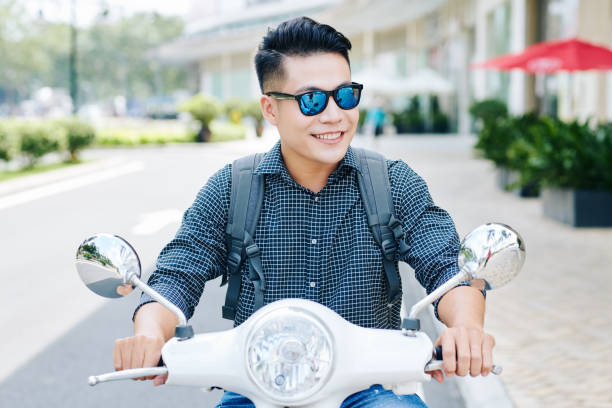istock Man riding in city streets on scooter 1172226087