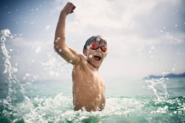 Little boy playing and splashing in sea waves Little boy having fun splashing in sea waves. The boy is jumping up with gesture of victory.
Nikon D850 jumping into water stock pictures, royalty-free photos & images