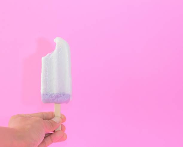 woman hand holding Taro flavor ice cream sticks on pink background. copy space for your text