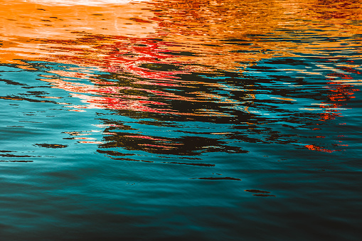 Abstract rippled water reflection - orange and turquoise colors