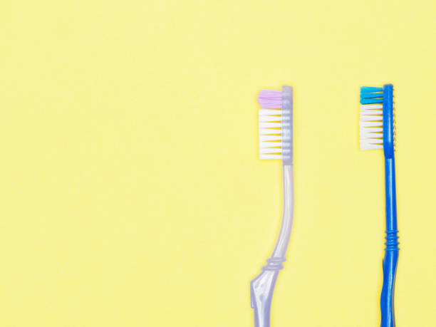 istock Toothbrushes on yellow background. Dental care concept 1172233455