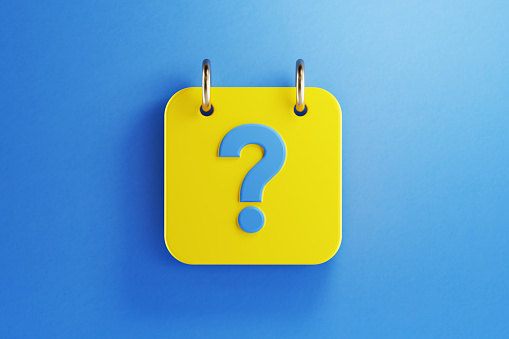 Yellow calendar with blue question mark on blue background. Horizontal composition with copy space. Top view.
