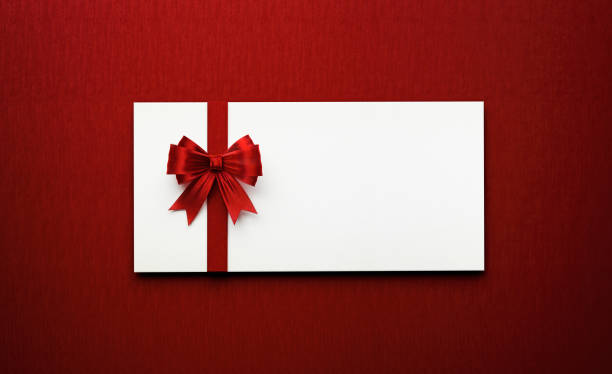 White Gift Card Tied with Red Colored Bow Tie on Red Background White gift card tied with red colored bow tie on red background. Horizontal composition with copy space. tied knot photos stock pictures, royalty-free photos & images