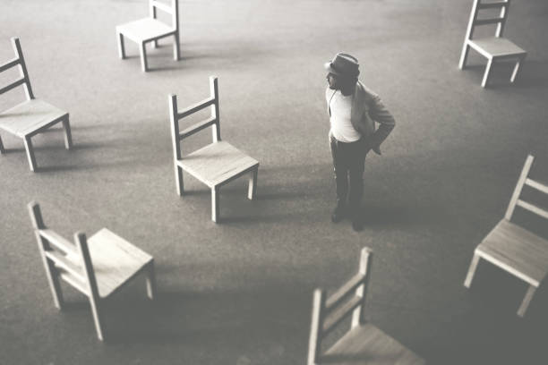 indecise man standing alone among wooden empty chairs, abstract concept