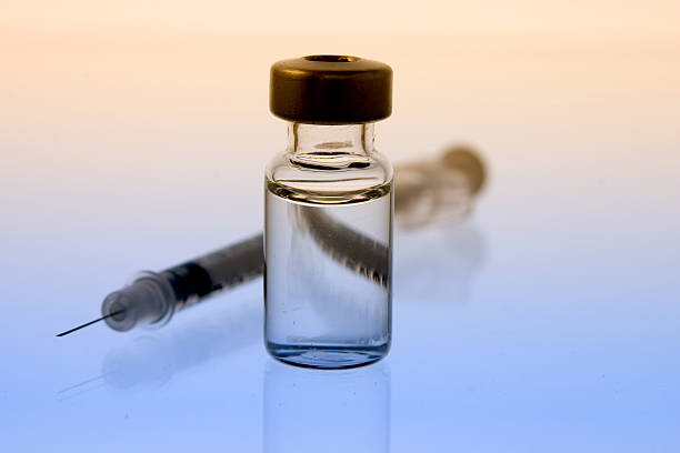 Vial of Clear Liquid with Syringe horizontal photo of clear liquid in a vial in front of a syringe morphine drug stock pictures, royalty-free photos & images