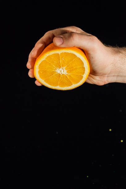 istock Man turns down half of an orange in his arm 1172244542
