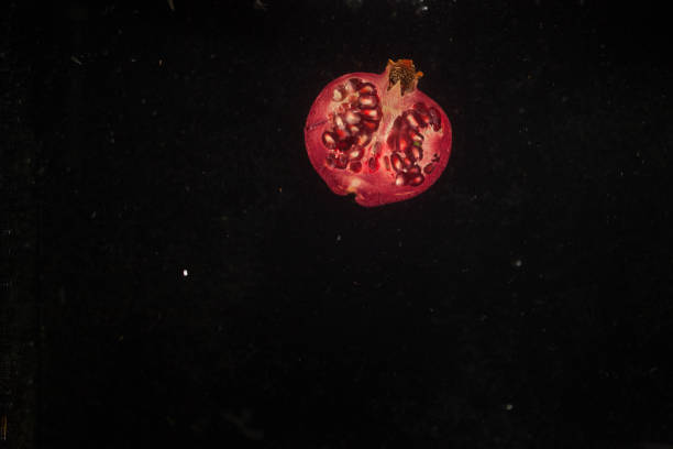 istock Half of red pomegranate falls calmly in water 1172247174