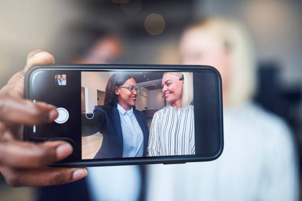 istock Two smiling young businesswoman using a cellphone to take selfies 1172251067