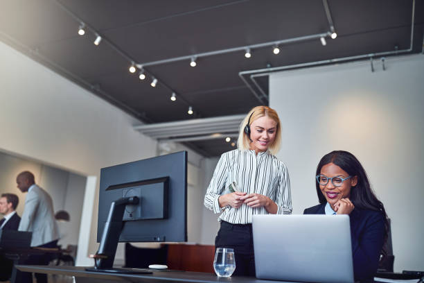 istock Two businesswomen smiling while looking at something on a laptop 1172251116