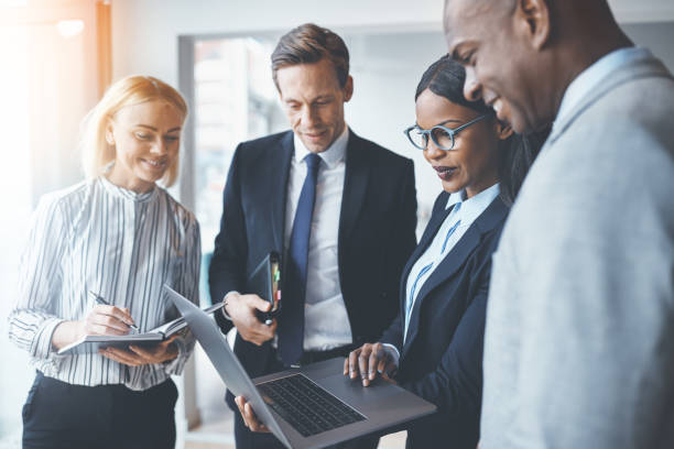 istock Diverse businesspeople smiling while using a laptop in an office 1172251290