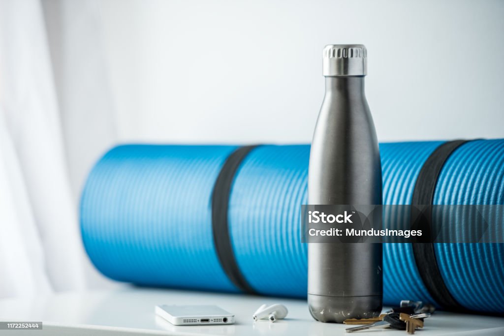 About to head to the gym and exercise We have a group of objects common to our daily lives such as a cell phone, car keys and water bottle, that conveys the idea of getting ready to go to the gym or exercise. Water Bottle Stock Photo