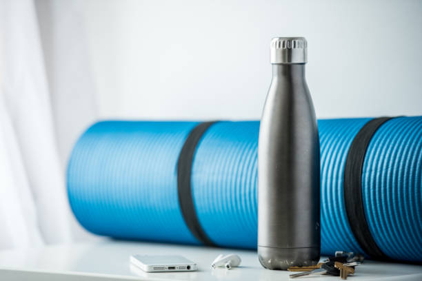 About to head to the gym and exercise We have a group of objects common to our daily lives such as a cell phone, car keys and water bottle, that conveys the idea of getting ready to go to the gym or exercise. bottled water on table stock pictures, royalty-free photos & images