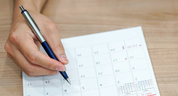 istock close up on employee man hand using pen to writing schedule on calendar to make appointment meeting or manage timetable each day , life balance concept 1172258770