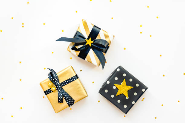 istock Gift box over star shaped golden sequins on a white background. 1172260460