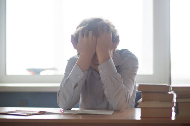 istock Schoolboy sitting at a Desk and doing homework. 1172268386