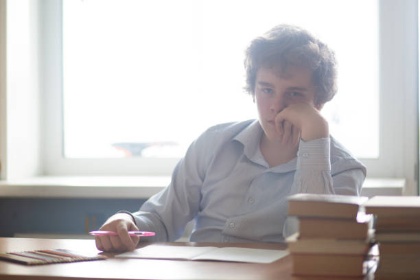 istock Schoolboy sitting at a Desk and doing homework. 1172268477