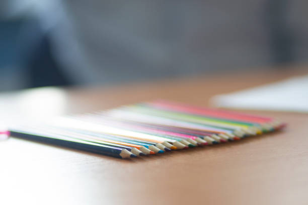 Colored pencils in the hands of a student. Schoolboy at his Desk.