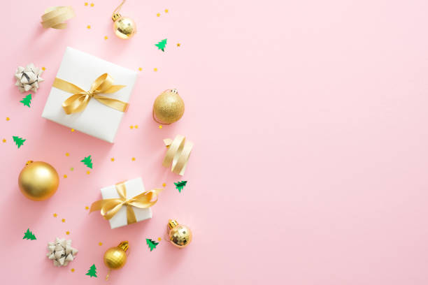 istock Christmas composition. Christmas golden decorations, gift boxes, baubles, confetti on pastel pink background with copy space. Flat lay, top view 1172269687