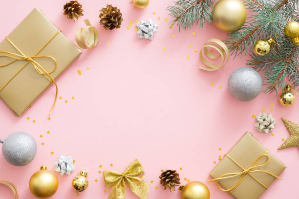 istock Christmas frame made of golden and silver balls, fir tree branches, decorations, gift boxes, pine cones on pastel pink background. Flat lay, top view, copy space. Christmas, winter, New Year concept 1172269732