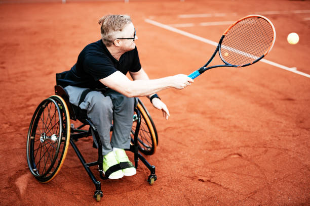 istock Disable man in wheelchair playing tennis 1172272015