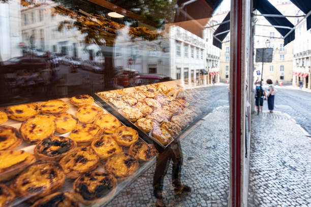 portuguese pastries behind glass portuguese pastries in lisbon behind bakery window with reflection of the city pasteis de belem stock pictures, royalty-free photos & images