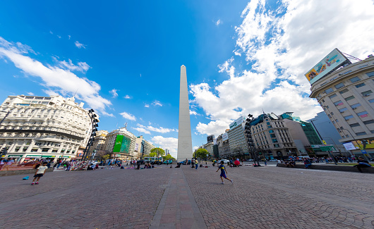 BUENOS AIRES, ARGENTINA - CIRCA FEBRUARY 2019: View on People pass by in front of the famous Obelisk landmark in the center of the city circa February 2019 in Buenos Aires, Argentina.