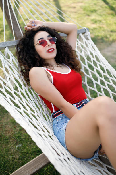 istock Young woman laying in hammock 1172275533