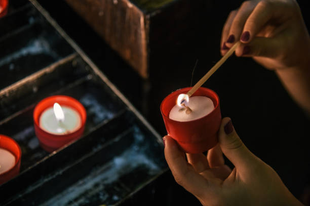 istock female hands lighting candle in church 1172276036