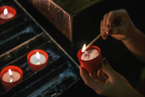 istock female hands lighting candle in church 1172276142