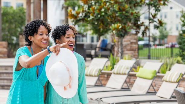 istock Identical twins standing by lounge chairs on patio 1172280182