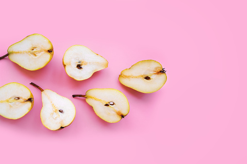 Fresh juicy pear on a pink background.  Ripe fruits. Concept of healthy eating. Flat lay.  Place for text.