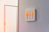 The busy toilet sign is marked in red, against the background is a door from the wc inside the plane.