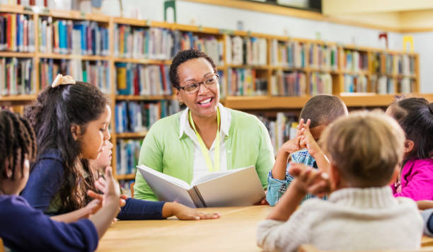 istock Teacher reading to children in library 1172283265