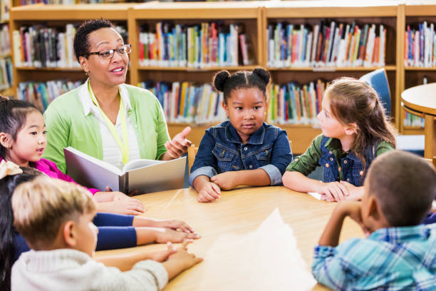 istock Teacher reading to children in library 1172283552