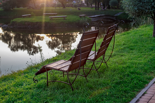 Rest zone. Wooden chairs stand on the grass by the lake, facing the lake. Belarus