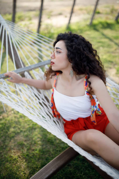 istock Young woman laying in hammock 1172284411