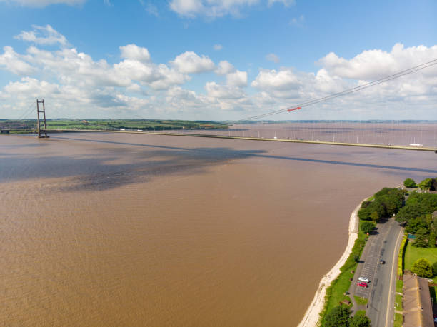 luftaufnahme der humber bridge, in der nähe von kingston upon hull, east riding of yorkshire, england, einspannbare straßenhängebrücke, aufgenommen an einem sonnigen tag mit ein paar weißen wolken am himmel. - humber bridge bridge humber river yorkshire stock-fotos und bilder